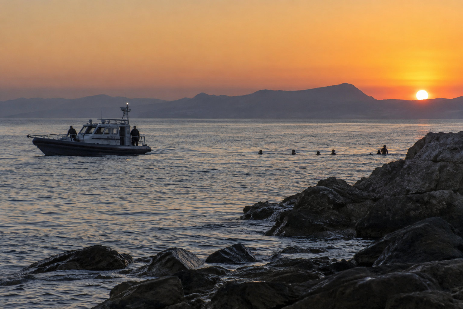 Spanische Küste mit Grenzboot auf dem Wasser als Symbol für die Debatte über schwimmende Grenzübertritte