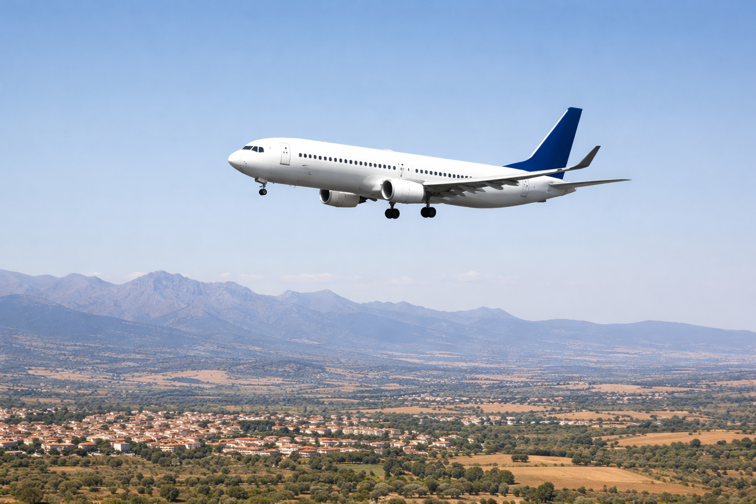 Passagierflugzeug fliegt über Landschaft in Spanien bei klarem Himmel
