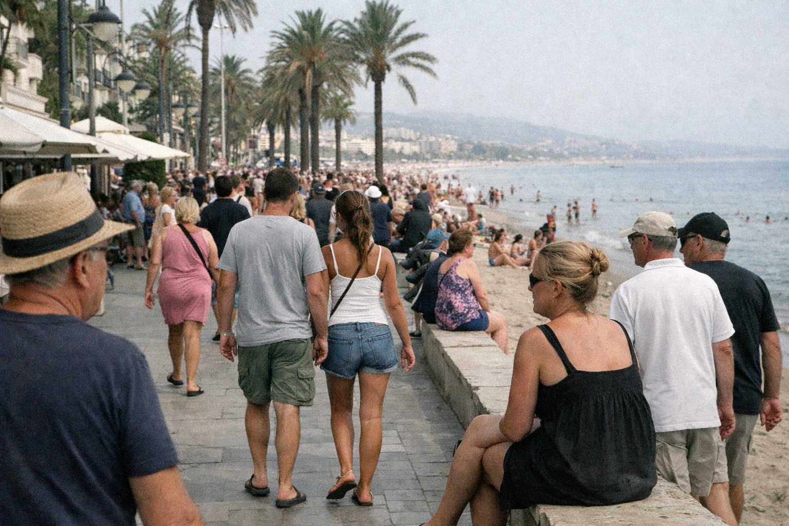 Viele Touristen auf einer Strandpromenade in Spanien während der Ferienzeit