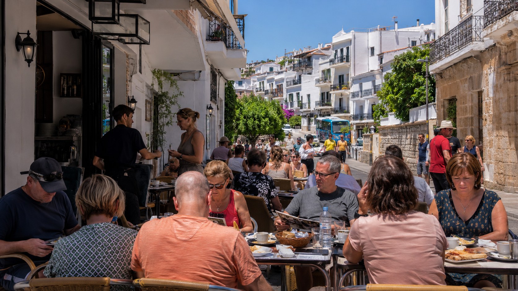 Urlauber sitzen in einem Restaurant in Spanien und essen auf einer sonnigen Terrasse